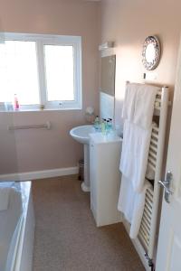 een badkamer met een wastafel, een toilet en een raam bij Armeria in Wells next the Sea