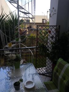 a balcony with a glass table and a fence at Barbara's appartment in Athens