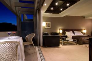 a hotel room with a bed and a table and chairs at The Athenian Callirhoe Exclusive Hotel in Athens