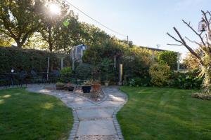 a garden with a stone path in the grass at Armeria in Wells next the Sea