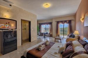 a bedroom with a large bed and a living room at Ghajn Damma in Xagħra