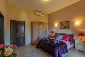 1 dormitorio con 1 cama con almohadas rosas y azules en Ghajn Damma en Xagħra