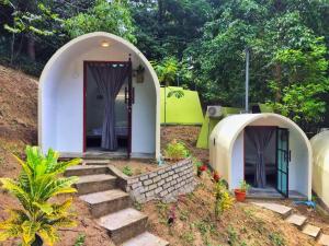 uma pequena casa com uma escada que leva a uma porta em Eco Capsule Resort at Teluk Bahang, Penang em Batu Ferringhi