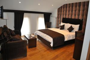 ein Schlafzimmer mit einem großen Bett und einem Stuhl in der Unterkunft Hotel de Savoie in Morges