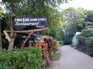 - un panneau indiquant un restaurant chanter à la maison à côté d'un chemin dans l'établissement Timasha Home Stay, à Tangalle
