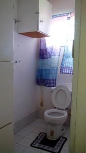 La salle de bains est pourvue de toilettes blanches et d'une fenêtre. dans l'établissement Don Santiago Guesthouse Downtown, à San Ignacio