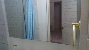 a bathroom with a mirror and a door with a shower at Don Santiago Guesthouse Downtown in San Ignacio