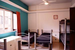 a room with three bunk beds and a window at Link Cordoba Hostel in Córdoba
