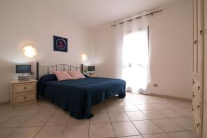 a bedroom with a bed and a dresser at Residence SardegnaSummer Li Cuppulati in San Teodoro