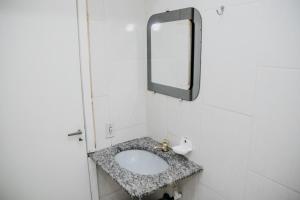 a bathroom with a sink and a mirror at Hotel Lumem Taguatinga Sul in Taguatinga