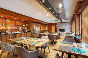 a restaurant with wooden tables and chairs and a kitchen at Bayerischer Hof in Freising