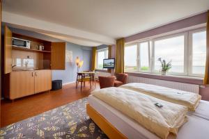 um quarto de hotel com uma cama grande e uma cozinha em Klassik Appartements em Helgoland