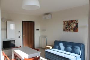 a living room with a blue couch and a table at Case Così Apartments - Verona in Verona