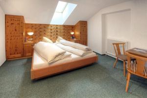 a bedroom with a bed with white pillows and a table at Appartement Kathi Scheiber in Sölden