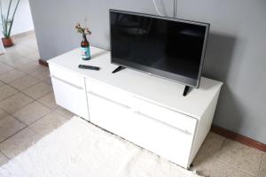 a white dresser with a television on top of it at Edifício José Augusto in Betim