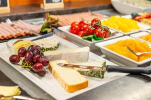 a buffet with cheese and other foods on plates at Bayerischer Hof in Freising