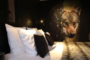 une tête de loup sur un mur à côté d'un lit dans l'établissement Les Loges Du Parc, à Gérardmer