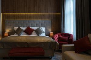 a bedroom with a large bed and a red chair at Dežman Luxury Center in Zagreb