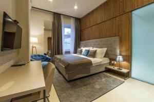 a bedroom with a bed and a desk and a television at Dežman Luxury Center in Zagreb