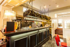 a bar in a restaurant with red chairs at Hotel Het Wethuys in Watou
