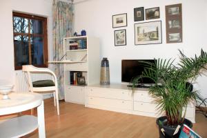 a living room with a television on a white cabinet at Haus zum kleinen Helm in Erfurt