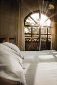 a bedroom with a bed and a window with the sun at Hotel Costa Choco in Bahía Solano