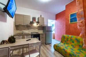 a kitchen and living room with a table and a couch at Krystall in Bibione