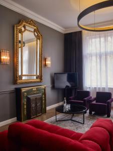 a living room with a red couch and a mirror at Hotel Collect - Adults Only in Budapest