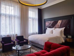 um quarto de hotel com uma cama, uma mesa e cadeiras em Hotel Collect - Adults Only em Budapeste