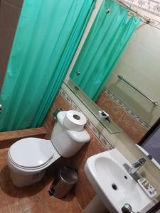 a bathroom with a toilet and a sink and a mirror at Alegria Hostal in Santiago de los Caballeros