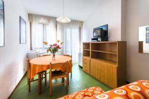 a small room with a table and a bedroom at Linz in Bibione