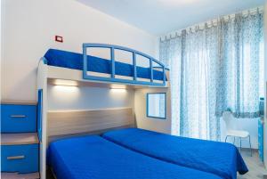 a bedroom with two bunk beds with blue sheets at Linz in Bibione