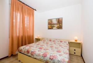 a bedroom with a bed with a floral bedspread at Olimpia in Bibione