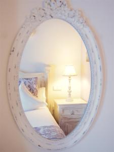 a mirror in a bedroom with a bed and a lamp at Hotel Abaco Altea in Altea