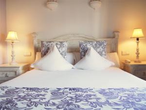 a bedroom with a large bed with two pillows at Hotel Abaco Altea in Altea