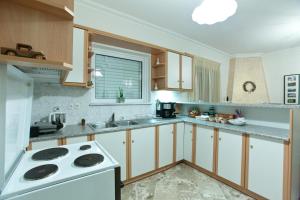 a kitchen with white appliances and a stove top oven at Villa PANORAMA in Levidi