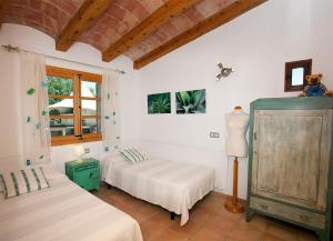 a bedroom with two beds and a window at Villa Can Eli by SunVillas Mallorca in Pollença