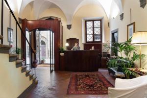 a woman standing at the reception desk in a lobby at Hotel L'Antico Pozzo in San Gimignano