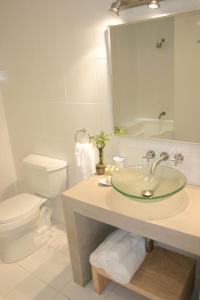 a bathroom with a sink and a toilet and a mirror at Hotel Piedraluna in Guatemala