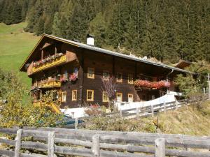een huis op een heuvel met een hek ervoor bij Apartments Obergraferhof in Innervillgraten