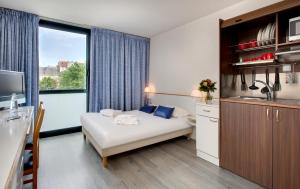 a hotel room with a bed and a large window at Hôtel des Thermes Les Dômes in Vichy