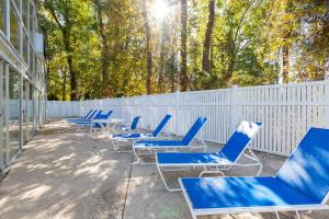 a row of blue chairs and a fence at Country Club Villas by Capital Vacations in Myrtle Beach