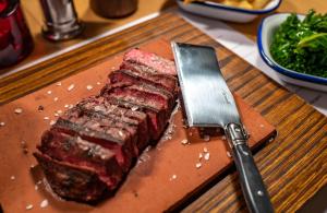 a piece of steak on a cutting board with a knife at Apollo Hotel in Basingstoke