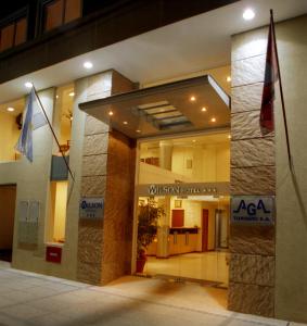 a building with two flags in front of it at Wilson Hotel in Salta