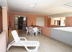 a patio with white chairs and tables in a house at Solarium/piscina in Bibione +3 photos