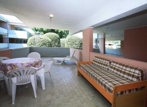 a balcony with a bench and a table and chairs at Solarium/piscina in Bibione