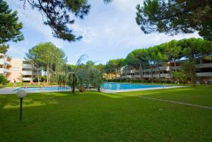 a resort with a swimming pool in a park at Solarium/piscina in Bibione