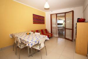 a dining room with a table and chairs and a couch at Solarium/piscina in Bibione