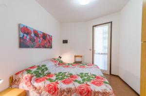 a bedroom with a bed with a floral bedspread at Tivoli in Bibione