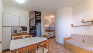 a kitchen and a living room with a table and a couch at Tivoli in Bibione
